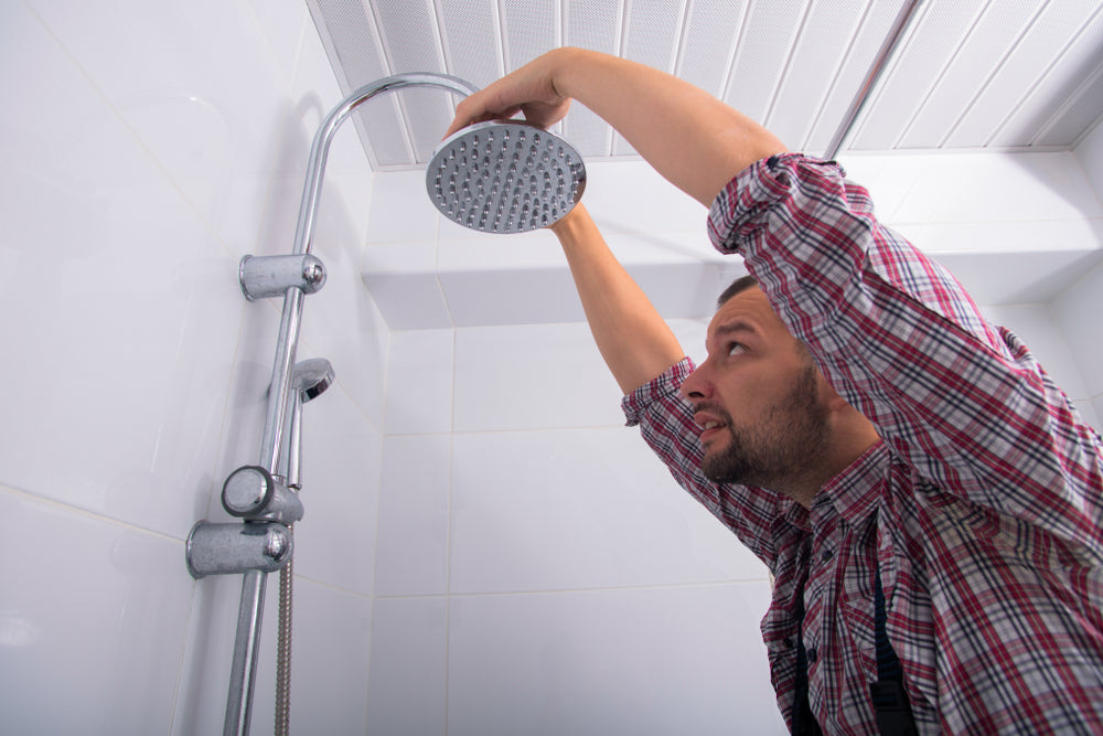 Hombre instalando un set de ducha 
